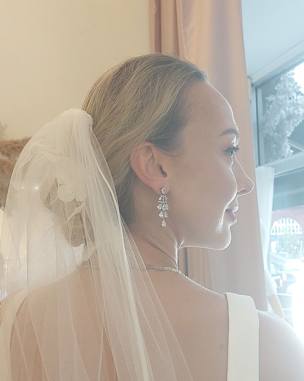 Close up of a bride wearing a veil, with her head turned to the side