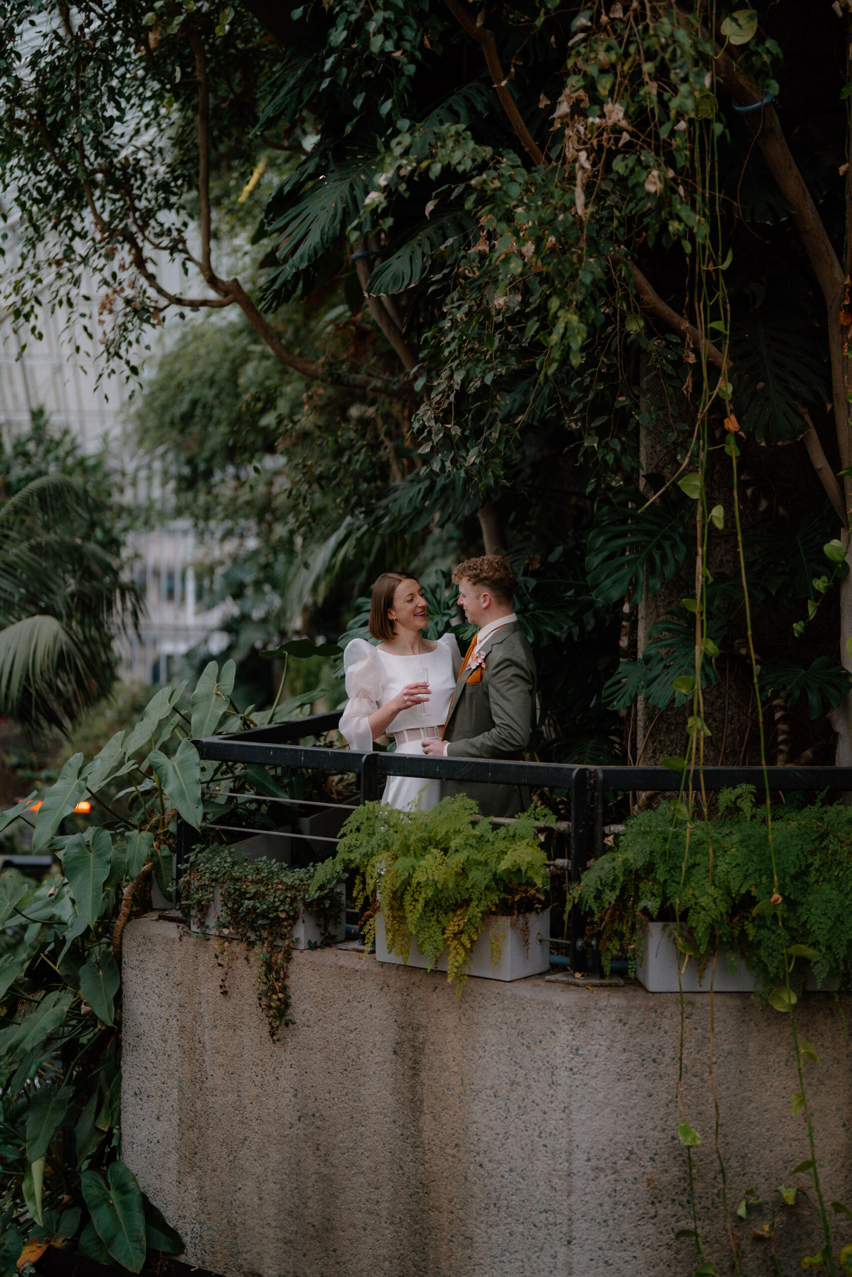 Groom and bride surrounded by lush greenery | modern London documentary wedding photographer Tom Aizenberg