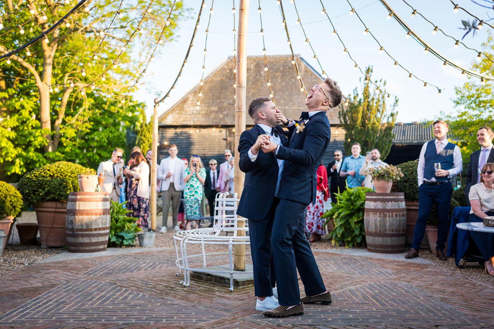 Two grooms dance and laugh at their Preston Court wedding - Benjamin Toms Photography | Kent