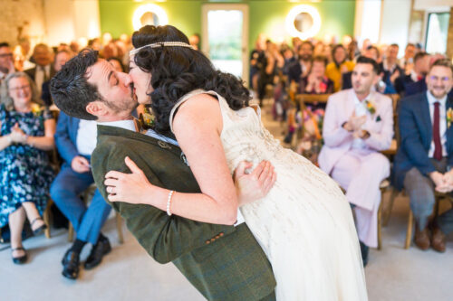 Groom and bride kiss passionately during their wedding ceremony - Benjamin Toms Photography | Kent