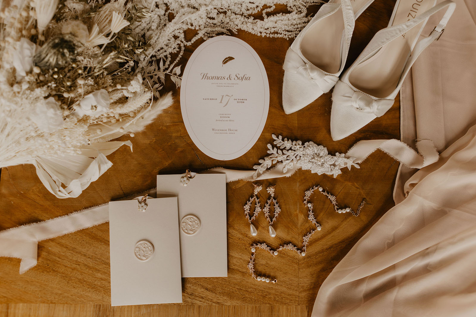 wedding stationery flatlay by Carrie at Honey Bee Mine with bridal jewellery, white wedding shoes and dried flowers, by Capture It
