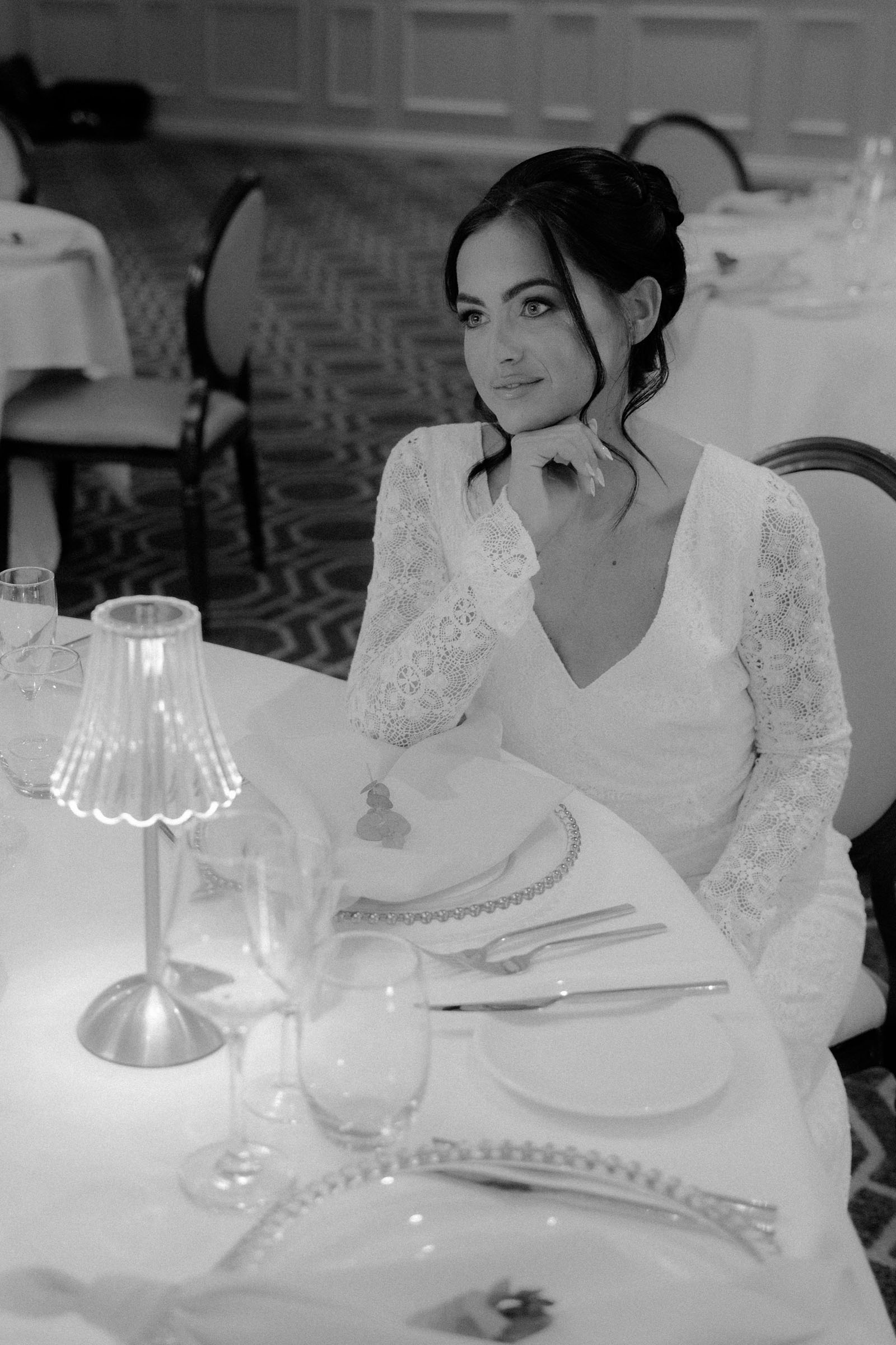 A woman wearing a wedding dress sits at a beautifully dressed table | photoshoot styled by Lauren Batten Events