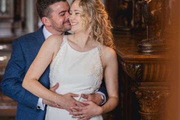 Romantic couple in wedding attire, arms around each other smiling - at Merewood Country House | Jaye Peg Photography Cumbria