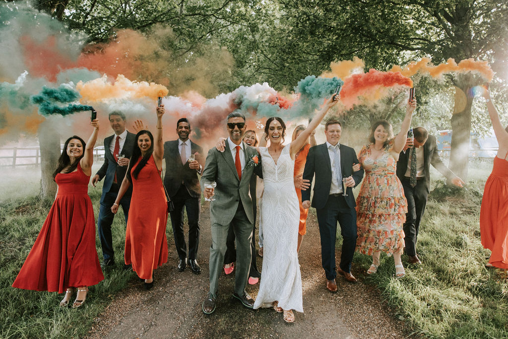 Green white and orange smoke held by a groom and bride and their guests at a Hertfordshire wedding | Nicki Shea Photography